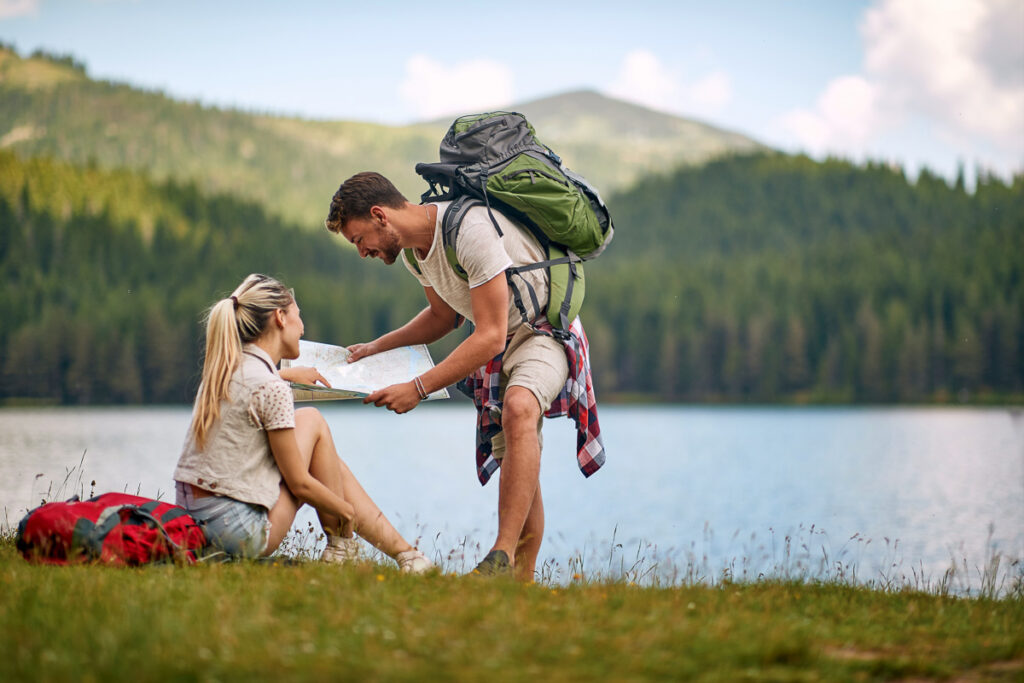 Young,Adult,Caucasian,Couple,Taking,A,Break,Of,Hiking,In